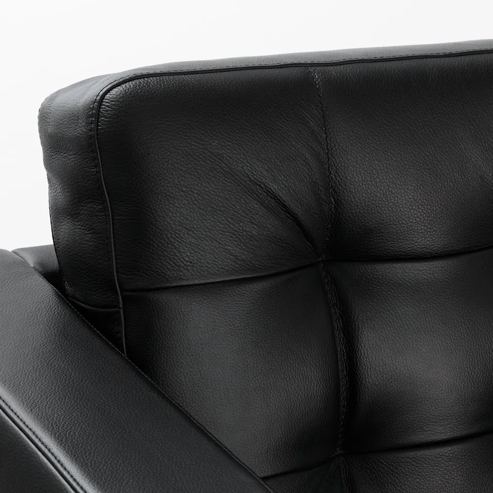 Black leather sofa close-up; smooth, grainy texture visible, showcasing luxury quality.
