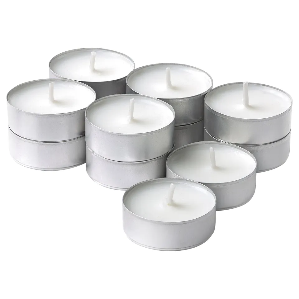 Six silver tealights, cylindrical with wicks, arranged in a circular pattern, gleaming metal reflecting light.