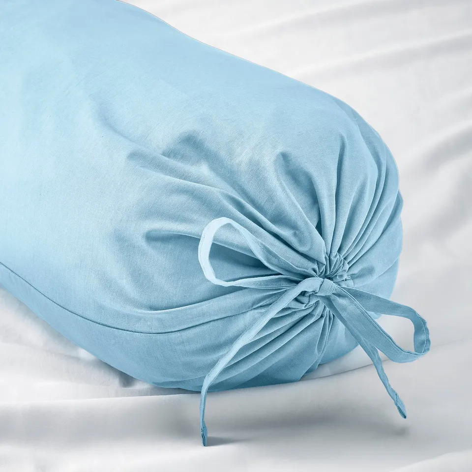 Light blue bolster pillow, tied with a bow, resting on a white surface. Soft, durable cotton material.