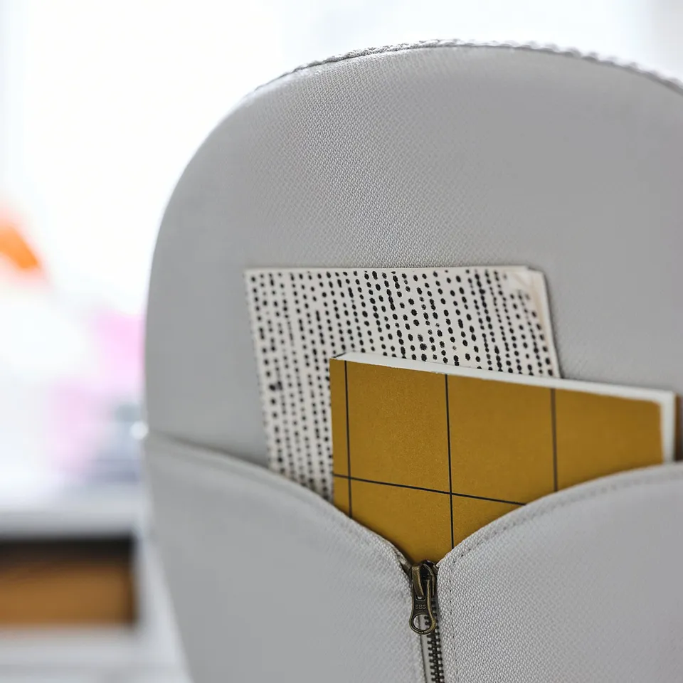 Grey BJÖRKBERGET office chair with yellow notepad pocket.
