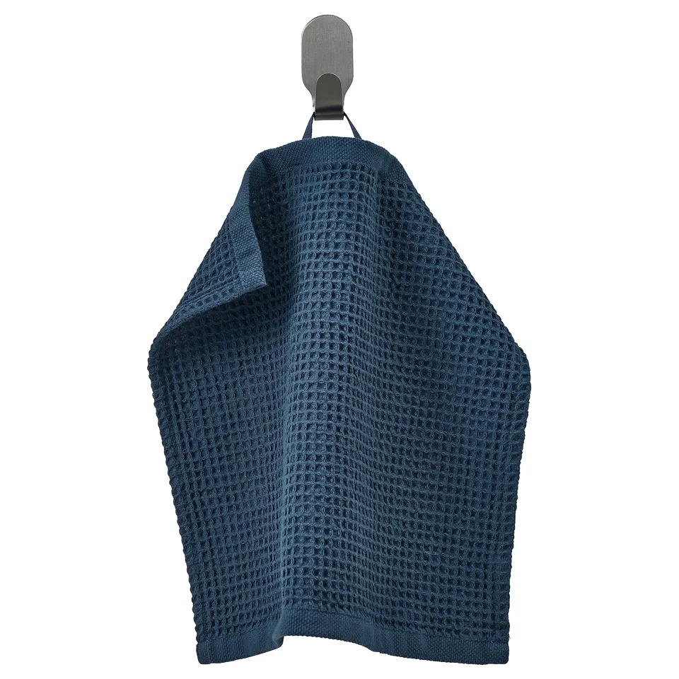 A dark blue GULLDYNA towel hanging on a hook. Made from 100% cotton, it a waffle texture and rectangular shape for kitchen use.