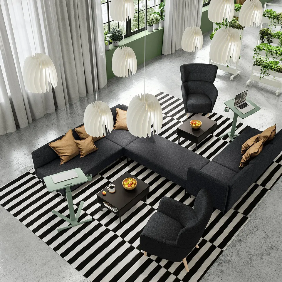 Modern lobby with height-adjustable laptop tables, grey seating, black-and-white striped rug, and unique white lamps.