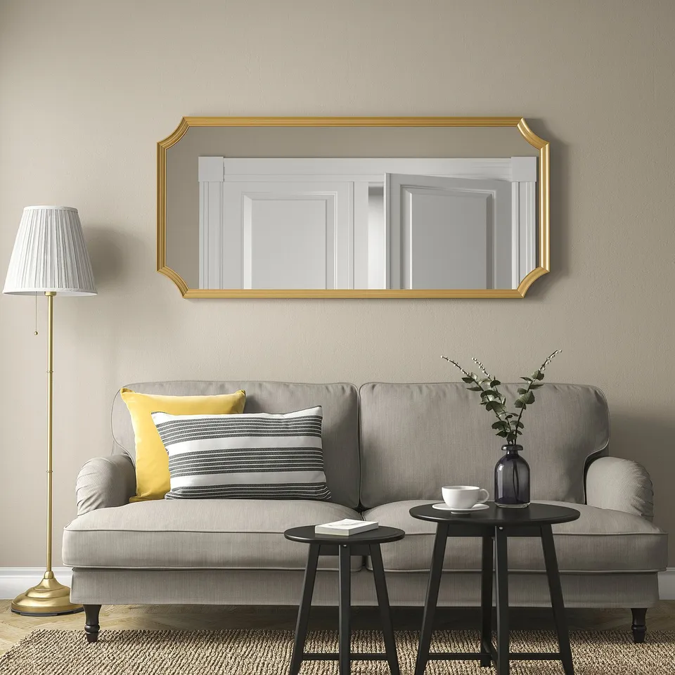 SVANSELE mirror with gold foil above grey sofa, complementing elegant living room.