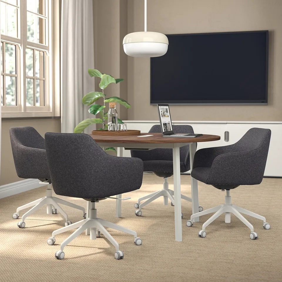 Small round MITTZON conference table with grey läktare chairs in a modern office setup. Perfect for small meetings, fits neatly under a large screen.