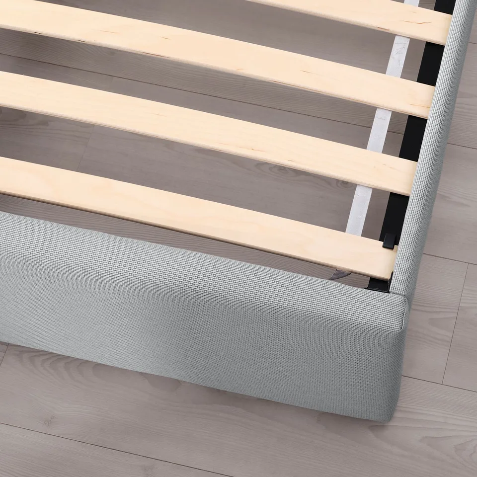 Close-up of GLADSTAD bed frame showing slats and grey upholstered headboard.