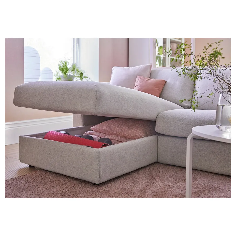 A VIMLE grey sofa-bed with storage and cushions in a cosy living room setting.