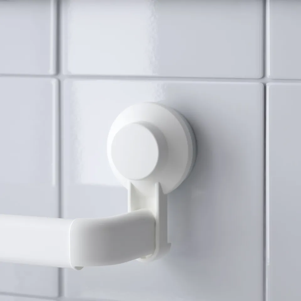 White suction cup mounted on tiled wall, securing a towel bar. Secure, functional, no-damage design.