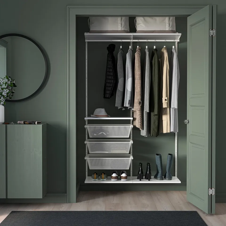 Green walk-in closet with wood floors, BOAXEL storage, mirror, & flowers.