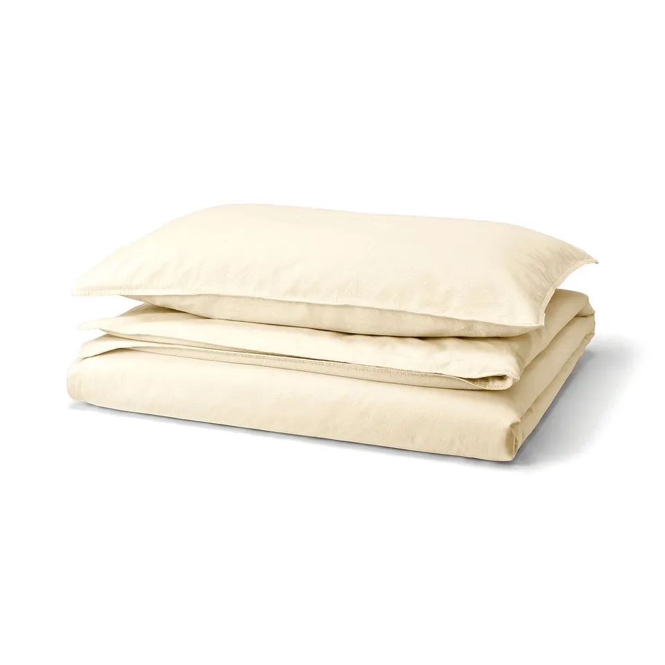 An ÄNGSLILJA duvet cover set in natural colour, made from 100% pre-washed cotton, rectangular with envelope closure and plastic press-stud details.