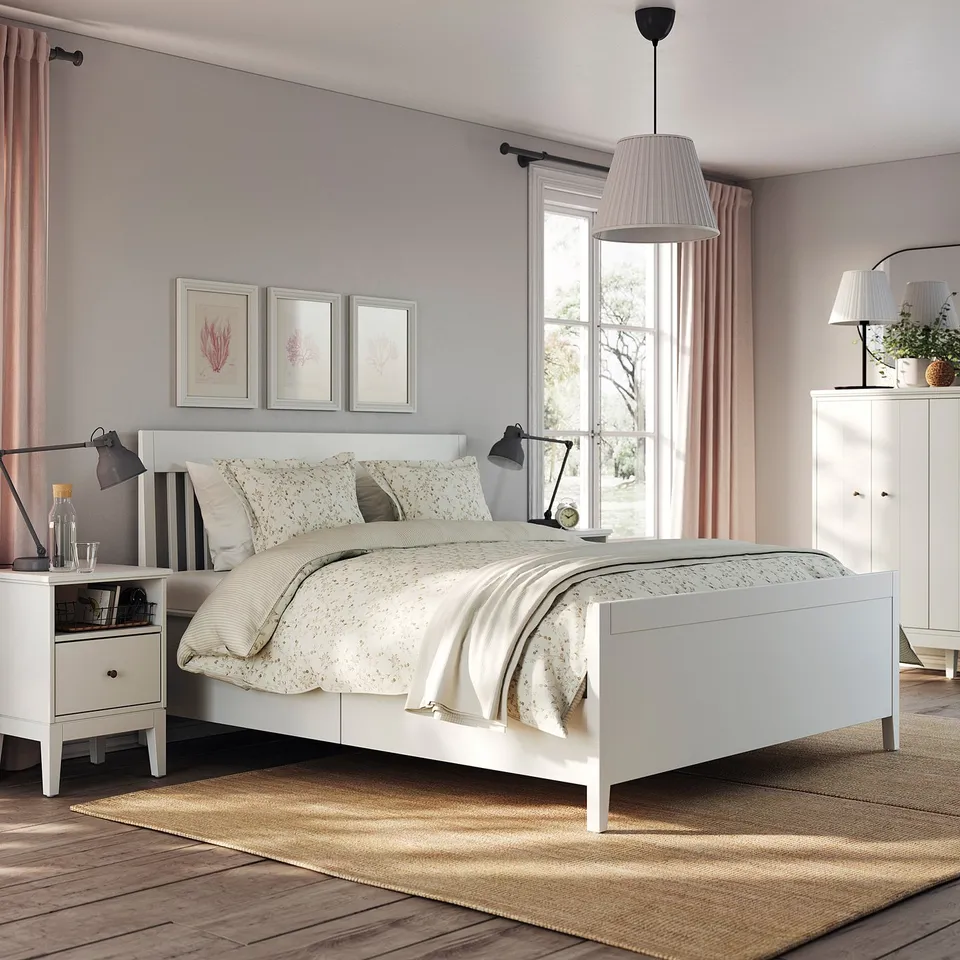 Modern bedroom featuring IDANÄS white bed with floral linens, nightstands, and pendant lamp.