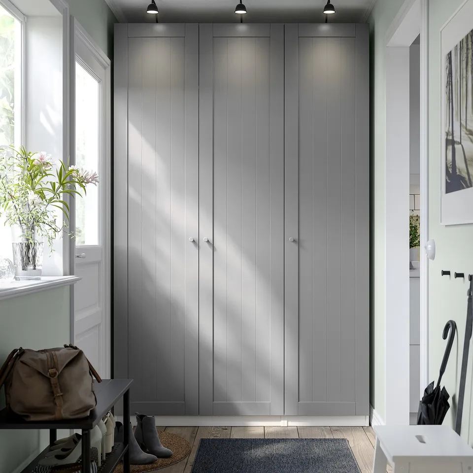 Modern, tall grey PAX wardrobe in entryway, surrounded by other furniture.