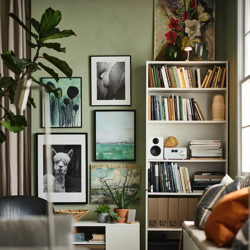 Modern living room with green walls, BILLY bookcases filled with books and decor.