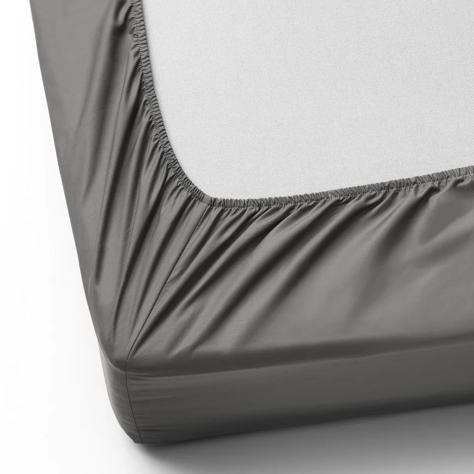 Grey fitted bedsheet with elastic corners, designed for mattresses up to 26 cm thick. Fabric is soft, breathable, and moisture-wicking.