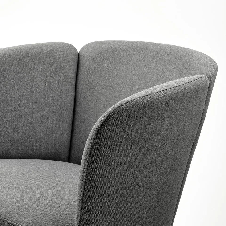 Close-up of HERRÅKRA armchair in grey fabric; smooth weave, bold design, rounded shapes.