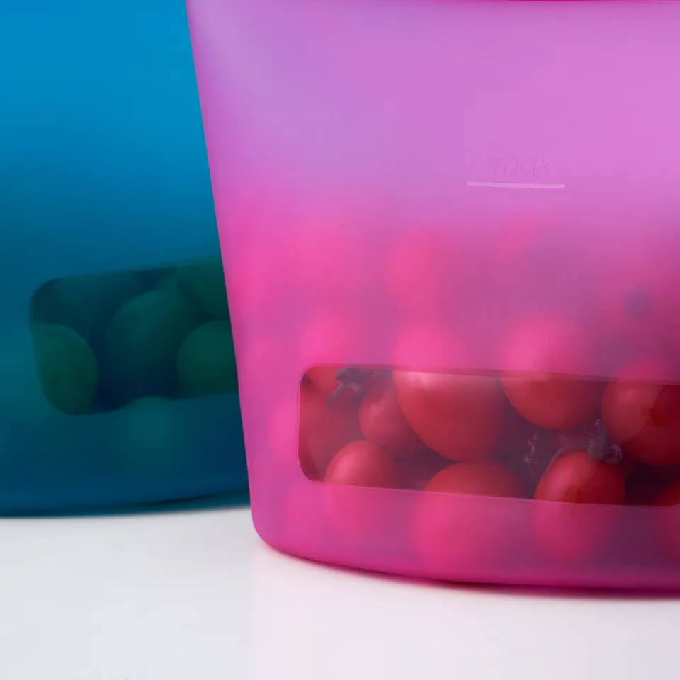 Two colourful silicone bags store foods; one holds red fruit.