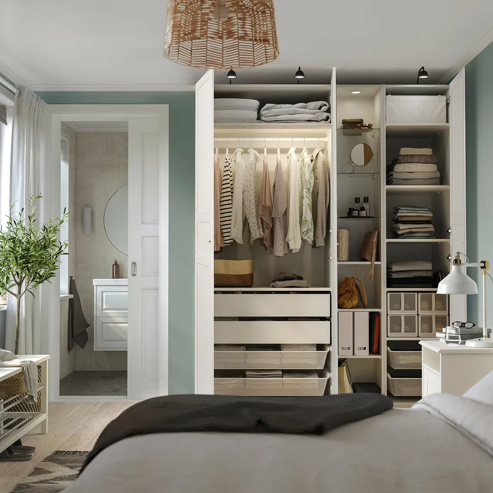 Bedroom with PAX wardrobe showing clothes, shelves, and drawers for organised storage.