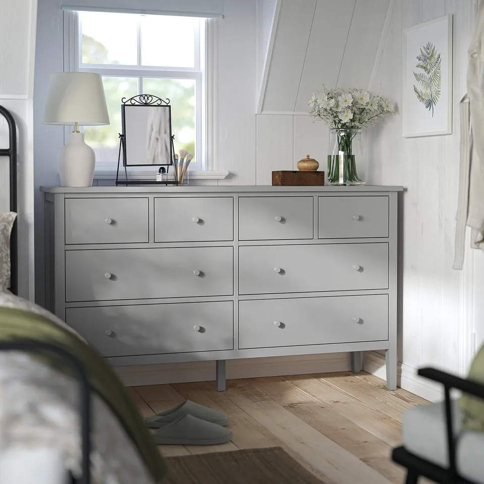 Grey GULLABERG dresser with 8 drawers against wall, near window. Modern design with round knobs.
