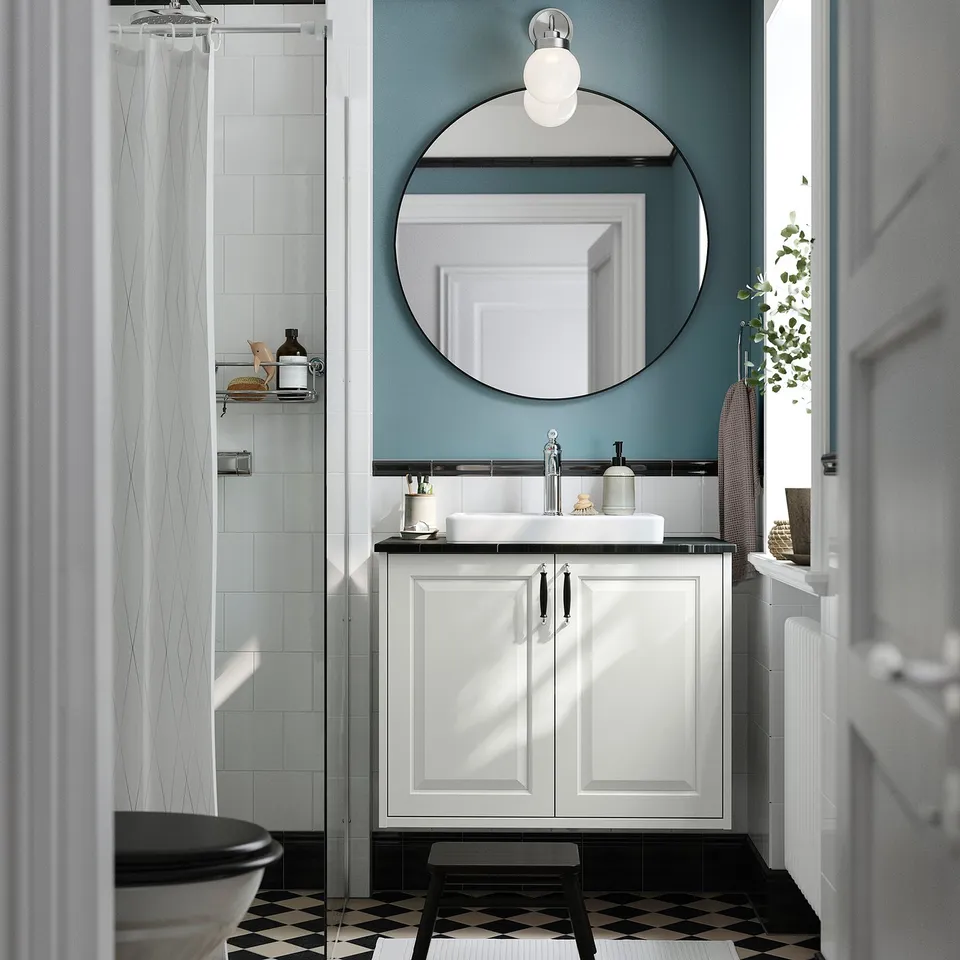 White bathroom cabinet with basin, mirror, black/white floor.