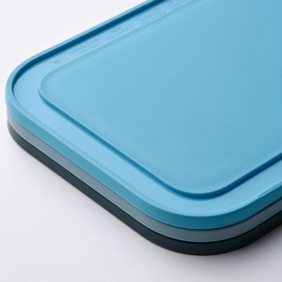 Rectangular blue plastic cutting board, smooth texture, good quality.