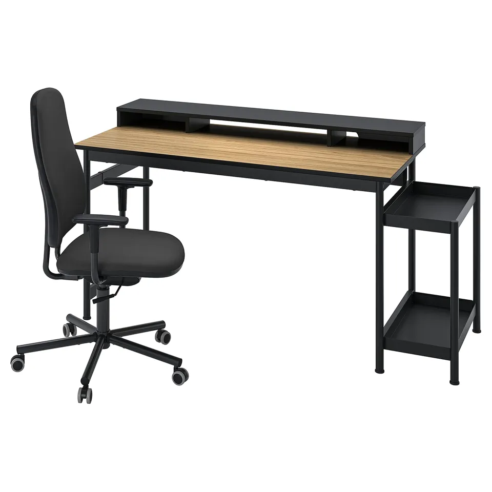 Black office chair with a swivel base beside a wooden desk featuring a keyboard tray. The desk has a black metal frame and a wooden top.