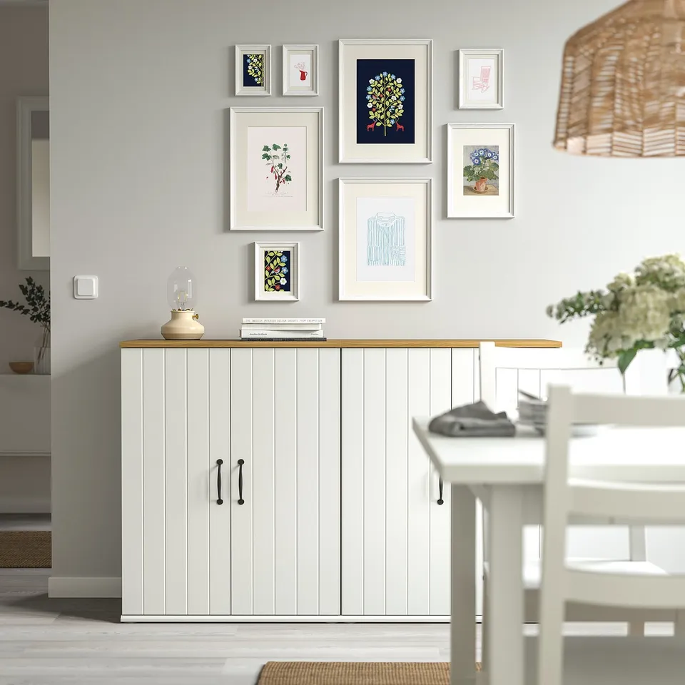 KNOPPÄNG cabinet with art gallery wall and lamp.