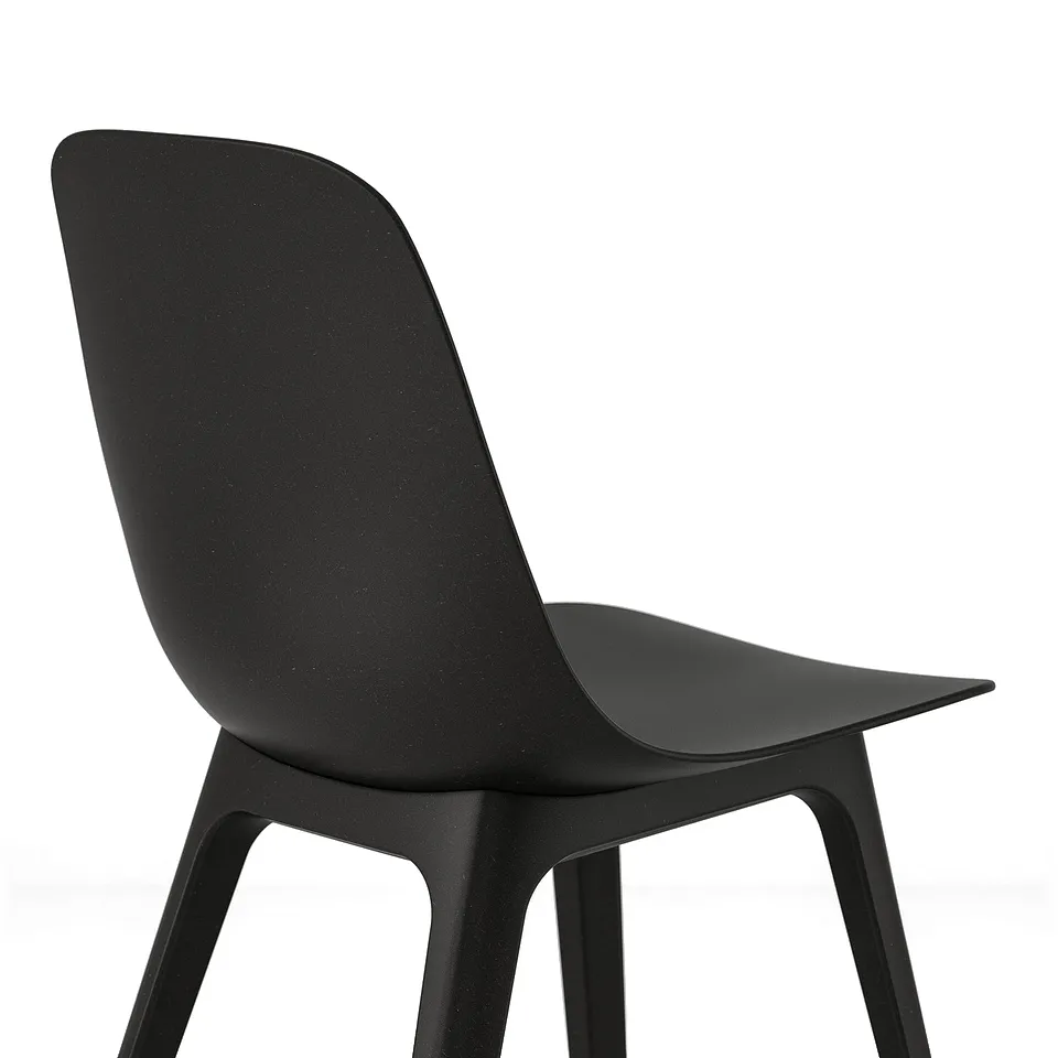 Black modern chair with sleek, curved seat and back, supported by four angled legs. Minimalist design.