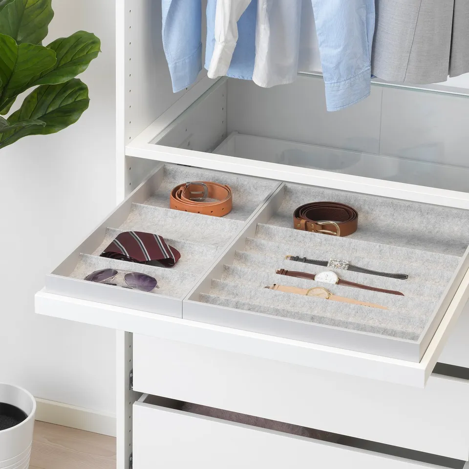 White drawer organiser with compartments for ties, belts, and watches on felt lining.