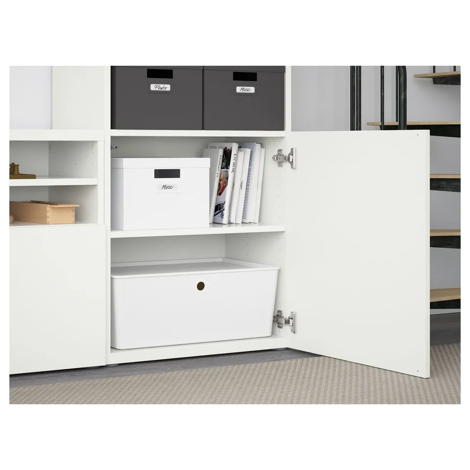 White BESTÅ shelf unit with adjustable shelves, drawers for organised storage, and cable management system in action.