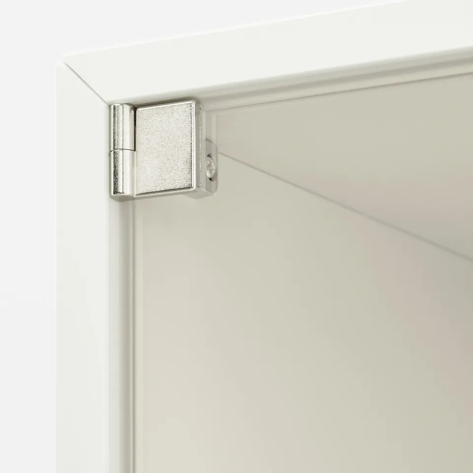 Close-up view of sleek, silver hinge on a modern, white cabinet, showcasing high-quality design and durability.