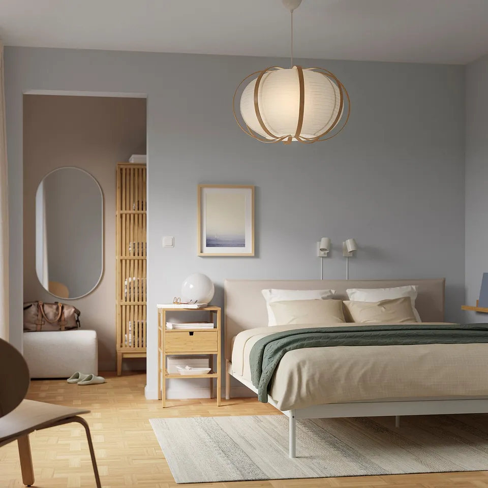 Minimalist bedroom with modern decor: white bed, light blue walls, TAGGTOFS bamboo pendant lamp.