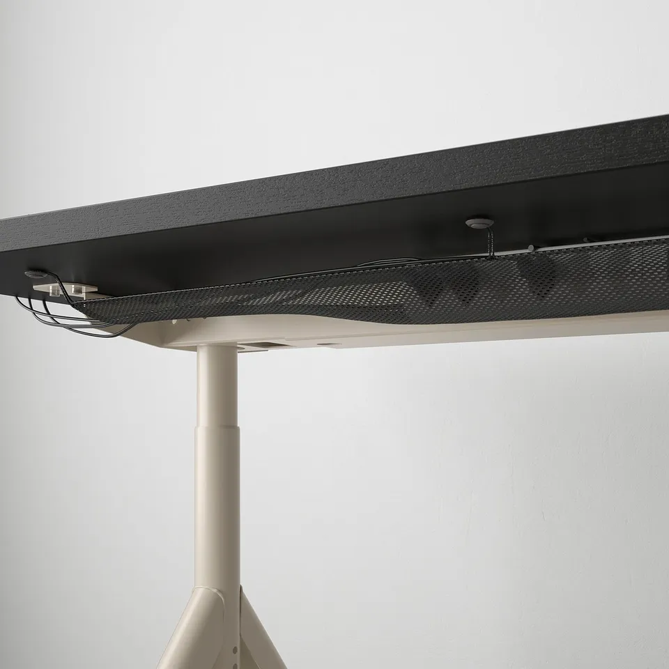 Desk with adjustable metal legs securing cables underneath.