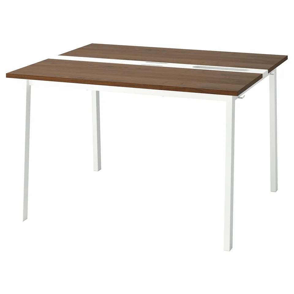 A MITTZON table with a rectangular shape and white metal legs. The top is dark brown woodgrain. The legs are straight, providing stability.