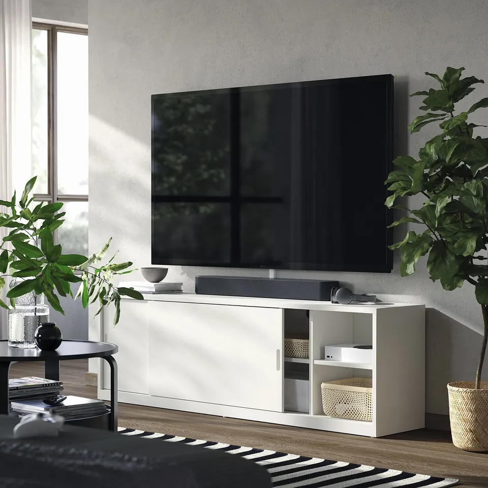 Modern living room with TONSTAD tv bench, sliding doors, plants, and rug.