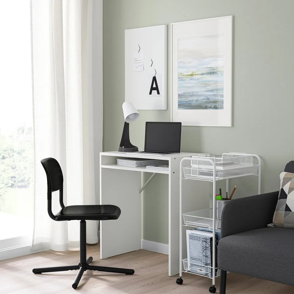 Minimalist home office with SMÄLLEN desk, black chair, grey sofa, laptop, lamp, and wall art.