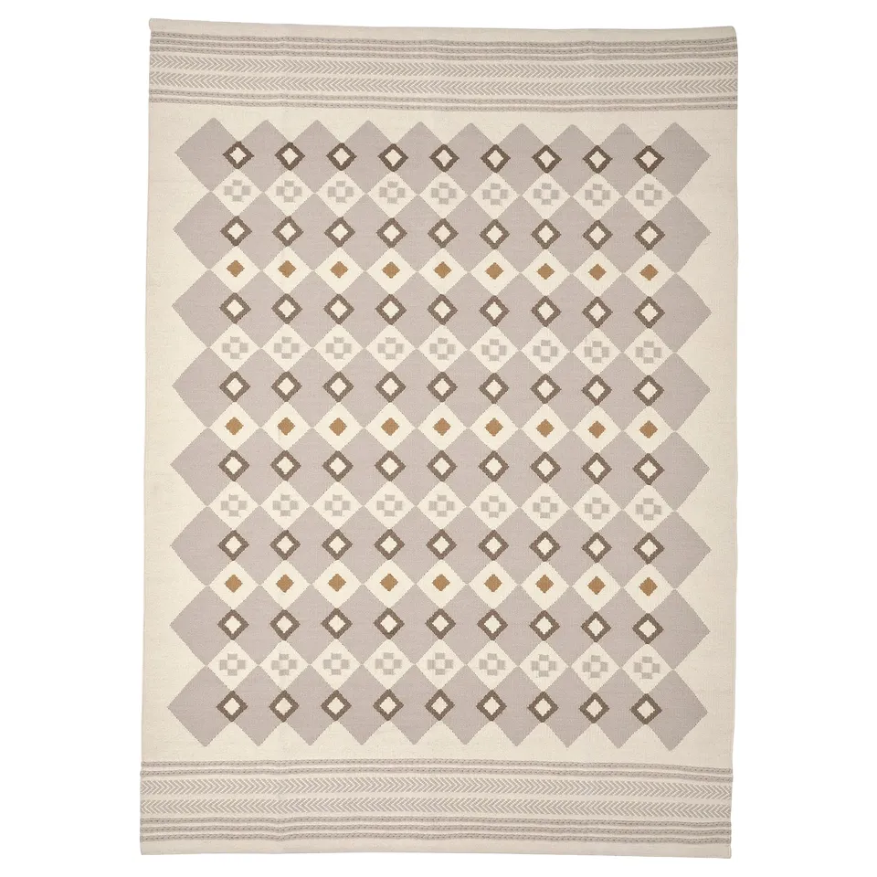 The VÄGNÄT rug in neutral grey and cream, featuring a traditional diamond pattern with handmade, intricate designs and wool material.