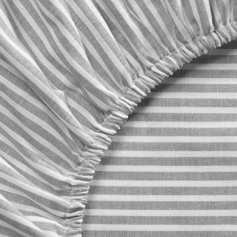 Grey striped bedsheet with fringe edges, neatly folded, showcasing quality cotton texture.