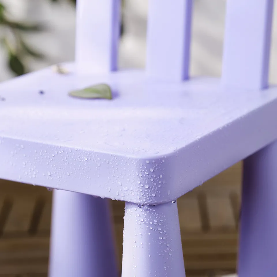 Light purple childrens table outdoors, wet from rain. Uv-protected plastic surface, easy to clean.