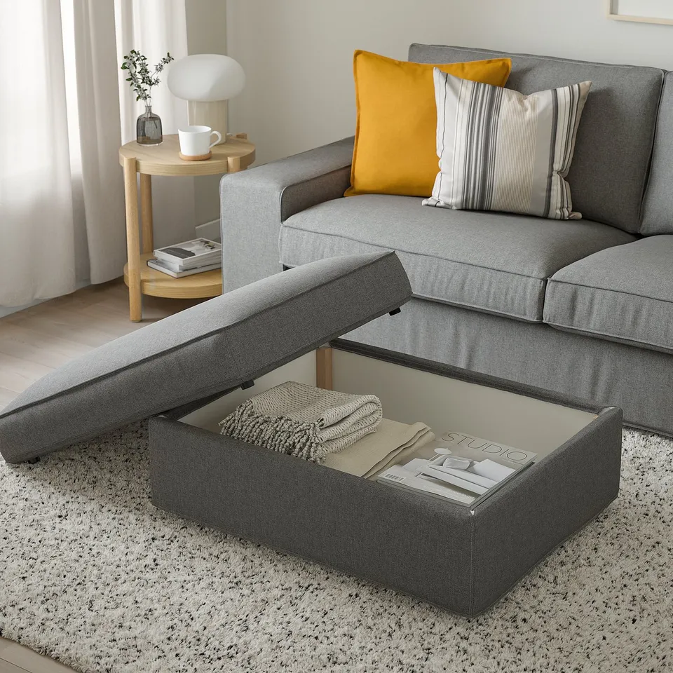 Modern living room with KIVIK sofa, yellow pillow, side table, lamp, plant, and blanket.