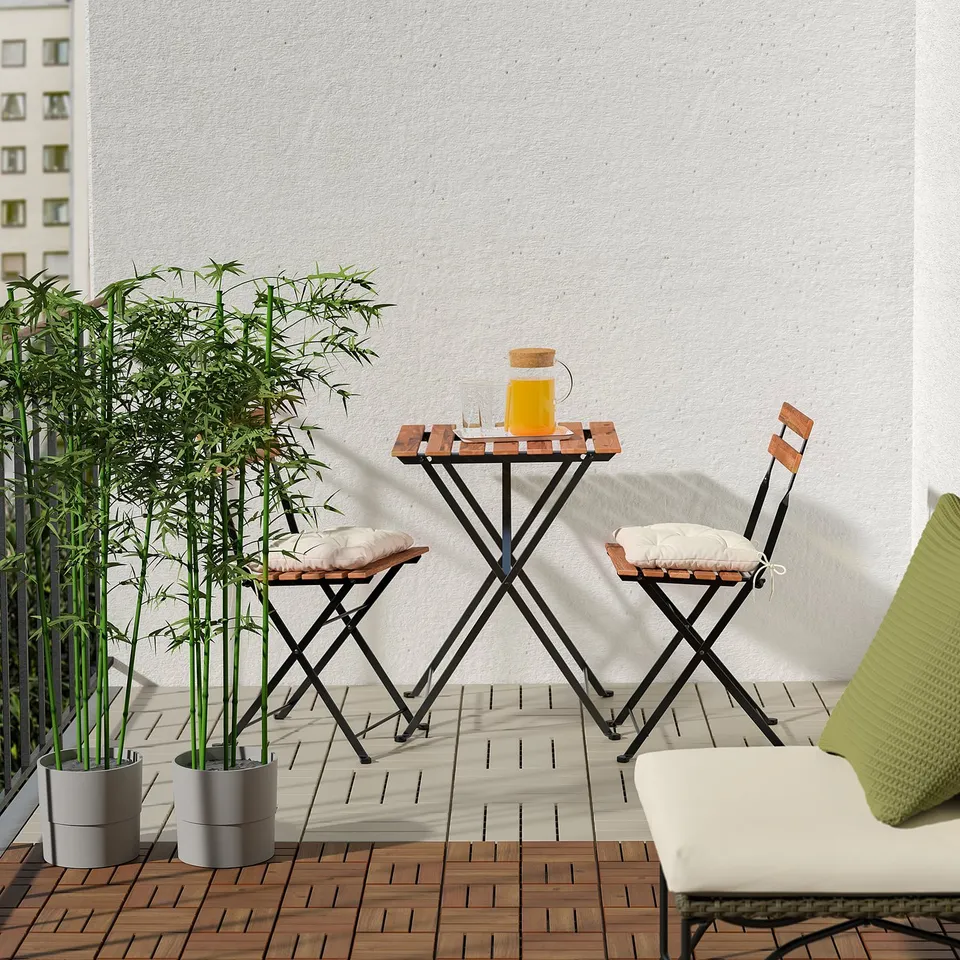 Balcony scene with RUNNEN decking, table, chair, plant, and drink.
