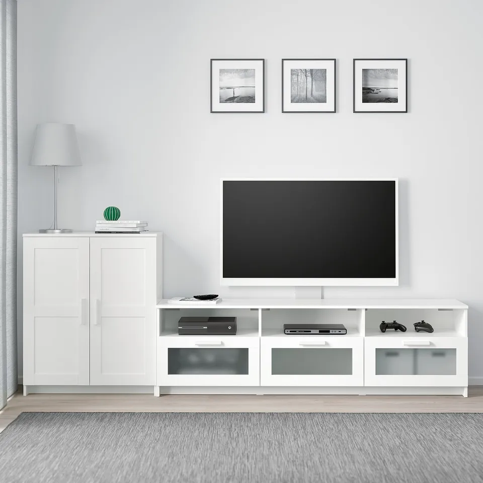 BRIMNES tv stand with flat-screen tv, shelves, and drawers. Matching cabinet, photos, and lamp. Minimalist modern setup.