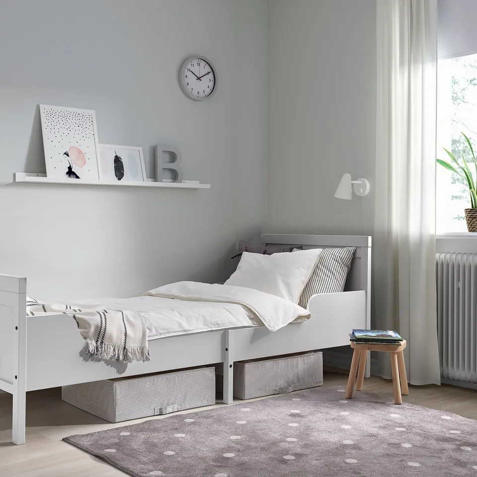 SUNDVIK kids bed, white, simple design. Grey walls, clock, storage, stool, rug, lamp, radiator.