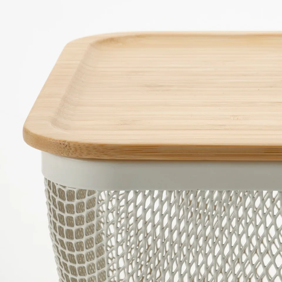 A close-up of a stylish IKEA 365+ storage basket with a bamboo lid, emphasising its sleek design and high-quality materials.