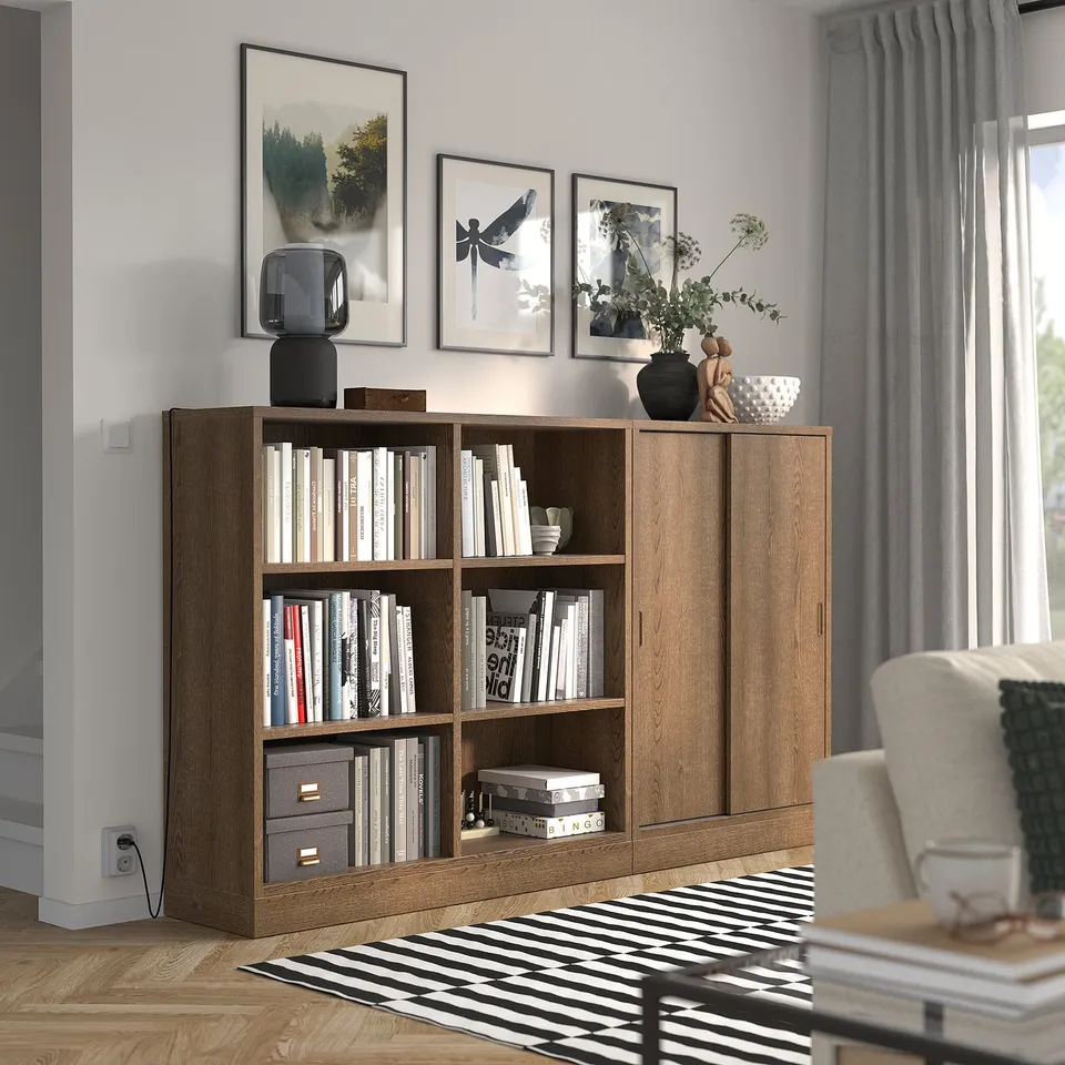 Honey oak TONSTAD bookcase, open & cabinet shelves, by window, cosy chair.