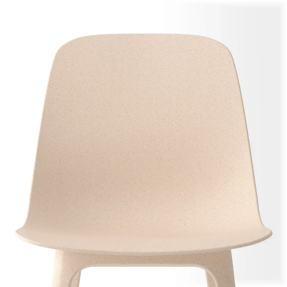 Beige chair, smooth, rounded curves, textured surface, inviting.