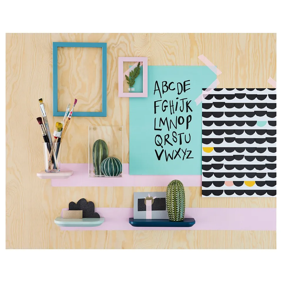 Wooden wall decor with colourful frames, pens, and ceramic cacti. Blue, pink, and green details.