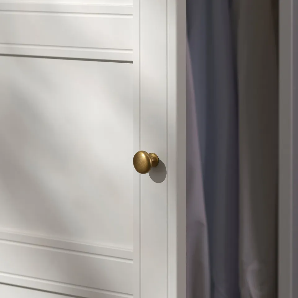 Close-up of smooth, white, panelled door with sleek, gold handle, reflecting high-quality craftsmanship.