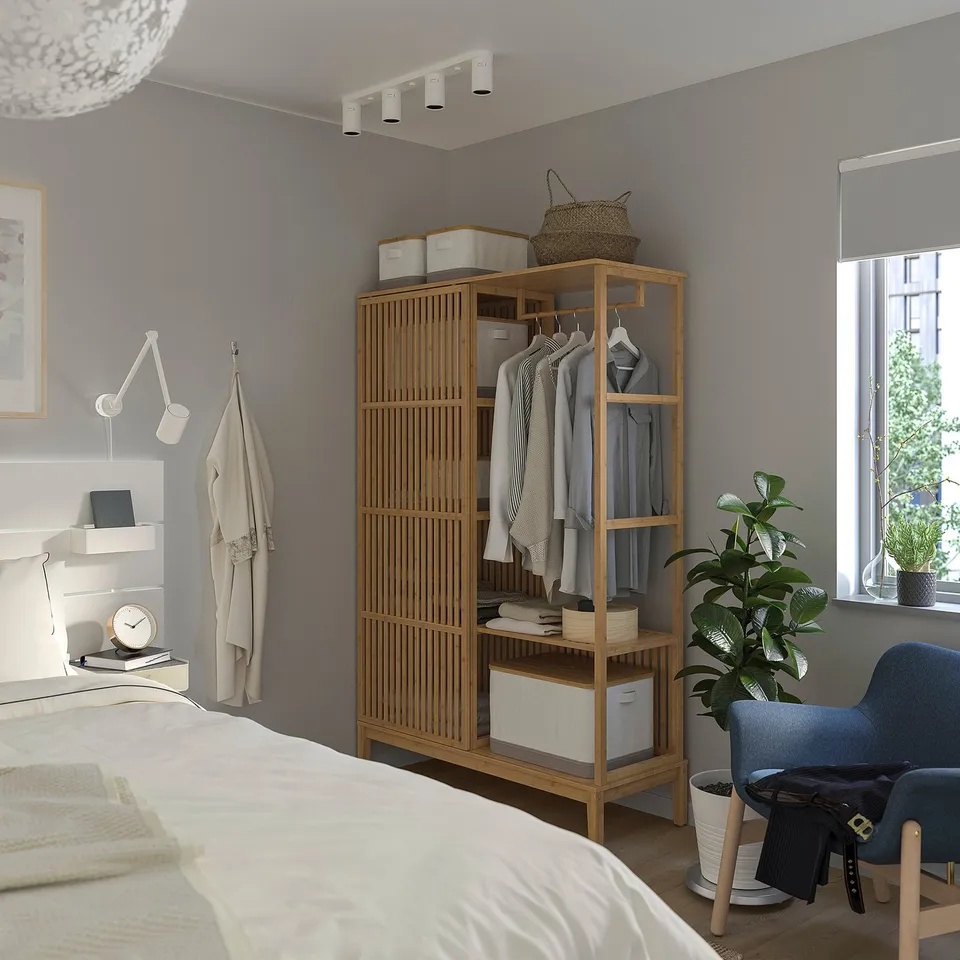 Modern bedroom with NORDKISA wardrobe, bed, chair, and plant.