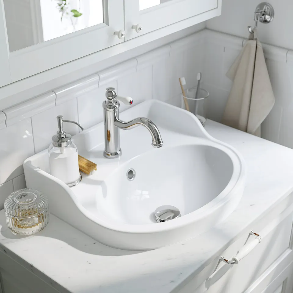 White sink, chrome fixtures, marble counter, soap dispenser, toothbrush holder.