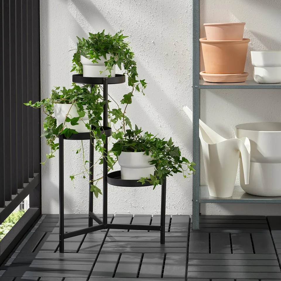 Three-tiered plant stand with white pots, displaying lush green plants, suitable for both indoor and outdoor use.