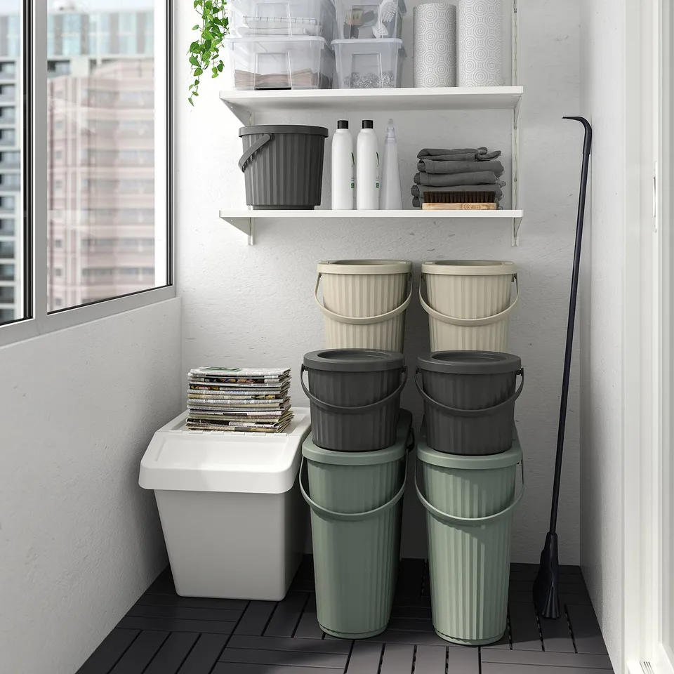 Stacked DAMMÄNG bins in various colours, small, cylindrical, polypropylene, fit under shelf with carry handle.